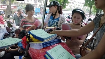 Thí sinh mua tài liệu ôn tập thi vào ngành thuế các năm trước do các trung tâm luyện thi bày bán công khai trước cổng trụ sở Cục Thuế Hà Nội. Ảnh: Quỳnh Nga